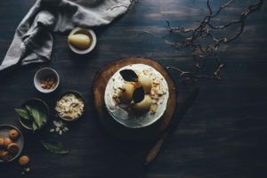 A rustic cheesecake topped with figs and nuts on a wooden board.