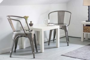 Minimalist dining area with metal chairs and a white table.