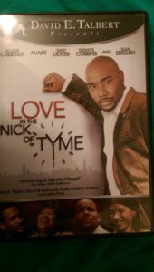 Promotional poster for 'Love in the Nick of Tyme' featuring a man in a brown suit.