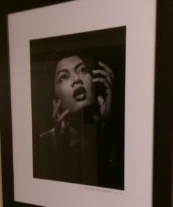 Black and white portrait of a person with expressive hands near their face.