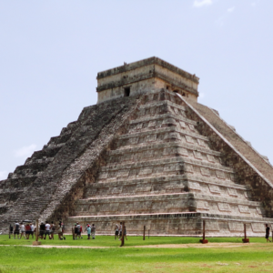 The ancient pyramid of Chichen Itza under a clear sky.