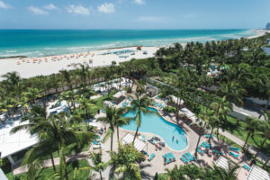 A tropical resort with a large pool and ocean view.
